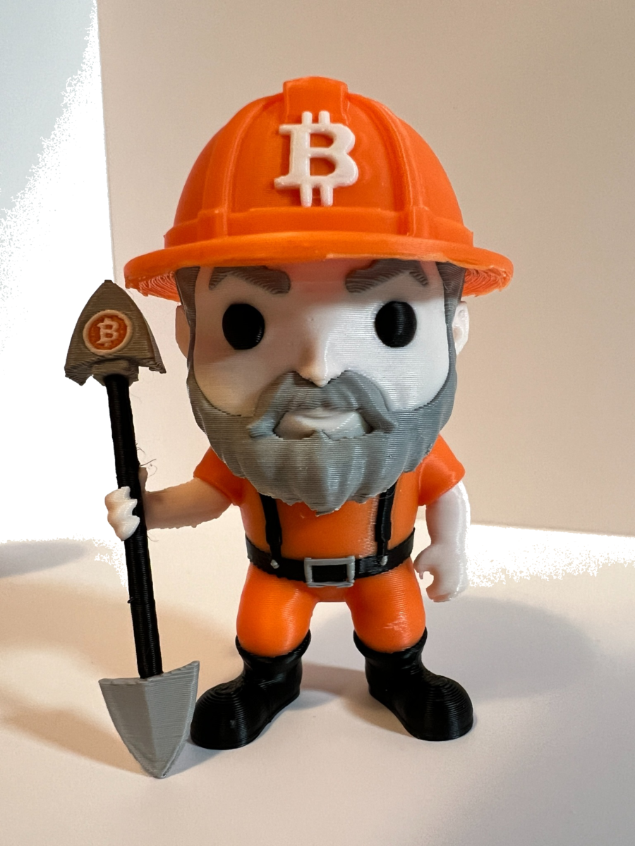 Close front view of the standard Bitcoin Miner Figure with orange hard hat and shovel