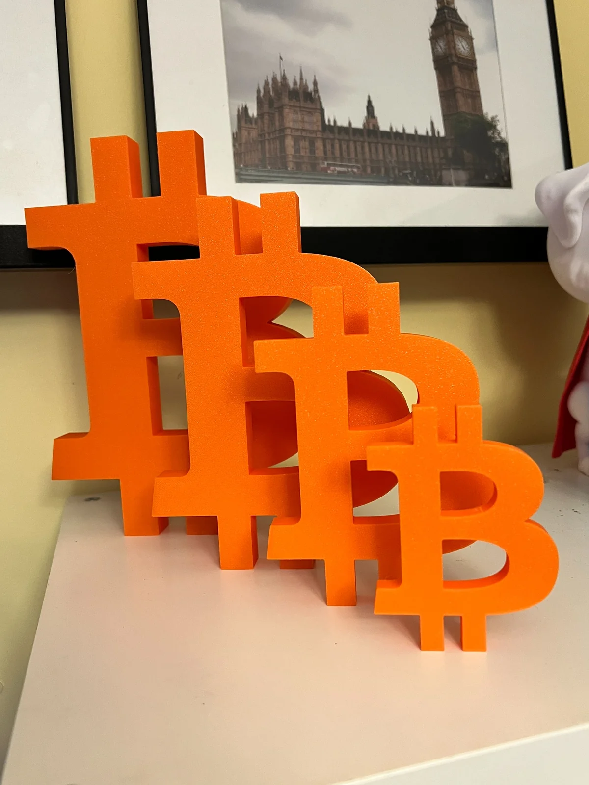 Orange 3D printed Bitcoin symbols in several sizes